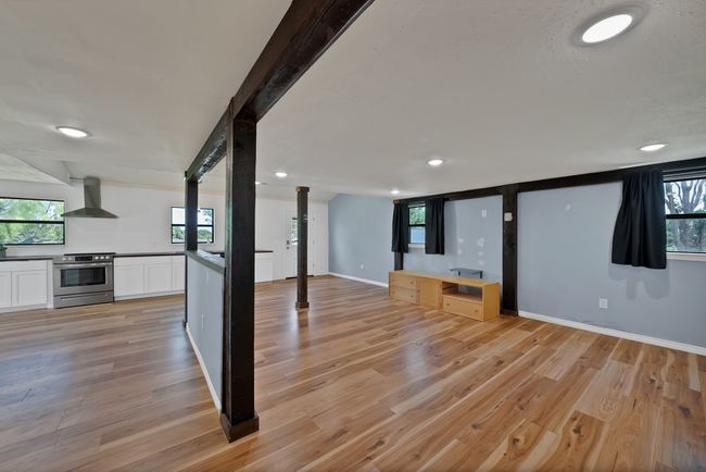 Unfurnished living room with light wood-style floors, recessed lighting, and ornate columns | Image 6