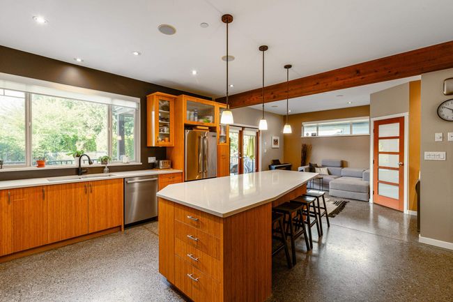 Kitchen featuring appliances with stainless steel finishes, french doors, a breakfast bar, a kitchen island, and light countertops | Image 10