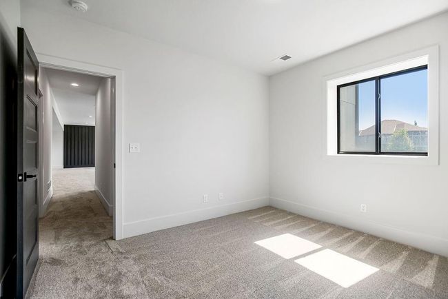 Carpeted empty room featuring a smoke detector and baseboards | Image 27