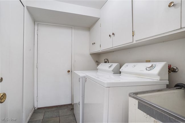 Laundry area with separate washer and dryer, baseboards, cabinet space, and a sink | Image 39