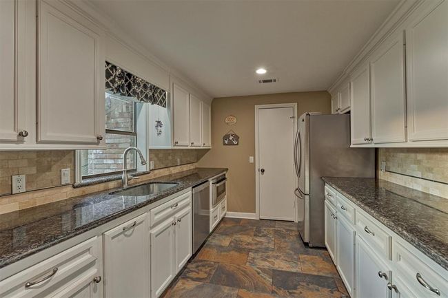 A closer look at the kitchen reveals a window over the sink with a view of the front yard. Just beyond, a pantry with shelving offers great storage. | Image 18