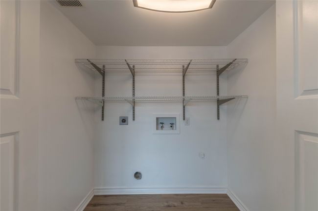 Laundry room featuring hookup for an electric dryer, washer hookup, wood finished floors, and baseboards | Image 5