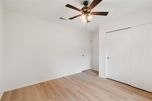 Closet doors and fan offer practical touches in a well-proportioned secondary room. | Image 20