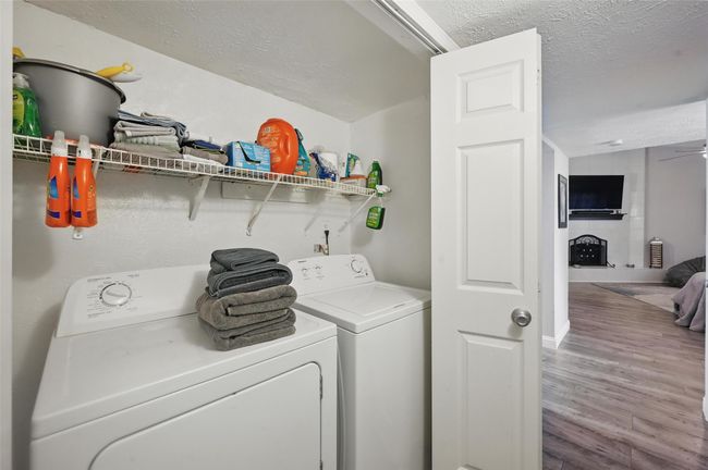 Laundry room featuring separate washer and dryer, a textured ceiling, wood finished floors, and a ceiling fan | Image 18