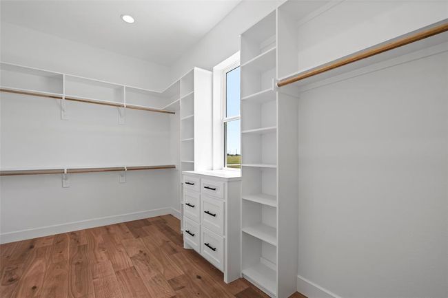 Spacious Hers walk-in closet in the primary bedroom, featuring ample shelving and natural light. | Image 27
