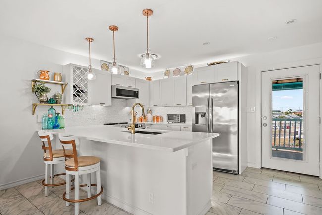 Bar top seating, upgraded lighting throughout kitchen and added natural light from front door. | Image 13