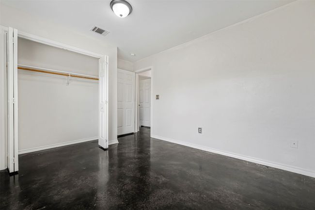 Unfurnished bedroom featuring concrete flooring and a closet | Image 25