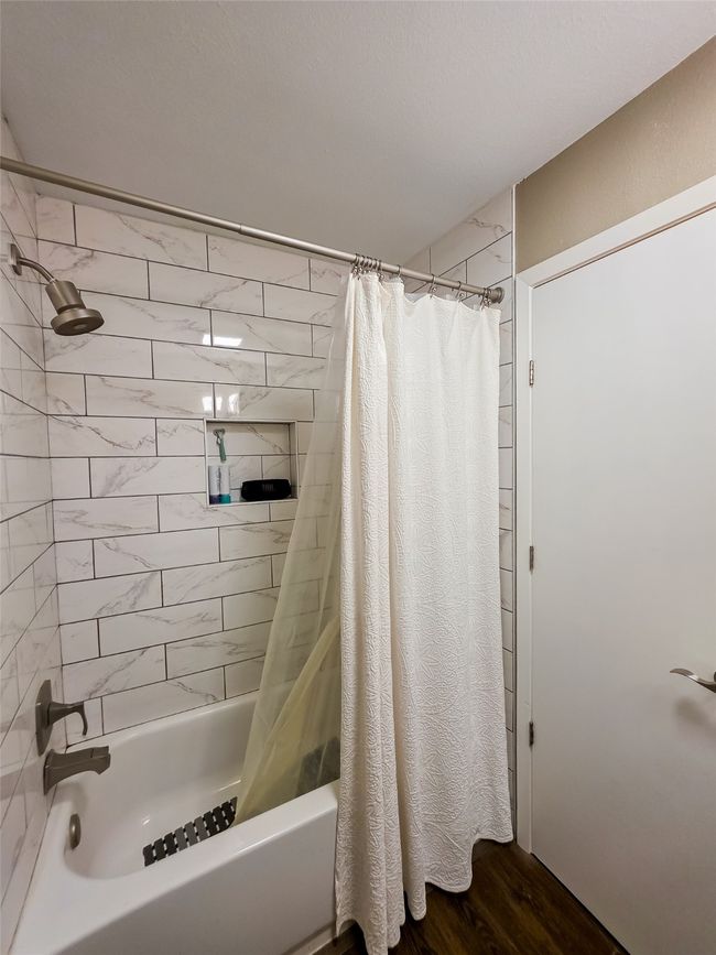 Bathroom featuring shower / bath combo and wood finished floors | Image 15