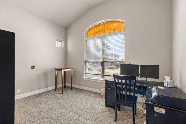 Carpeted home office with vaulted ceiling and baseboards | Image 22