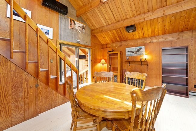 Dining room featuring wood finished floors, wooden walls, stairs, and wood ceiling | Image 20