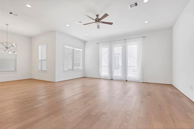 Spacious family room on the 2nd floor featuring large glass doors leading to a small balcony, allowing for plenty of natural light & a view. | Image 6