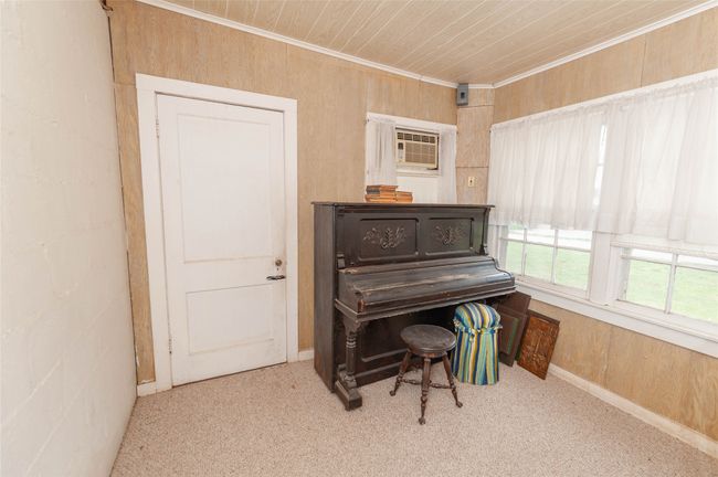 Sitting room featuring wooden walls, wood ceiling, crown molding, and carpet floors | Image 18