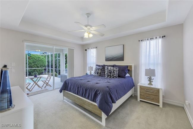 Carpeted bedroom featuring ceiling fan, access to outside, and a tray ceiling | Image 11