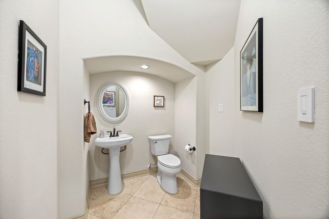 The first floor half bath is tucked away off the foyer under the sweeping staircase. | Image 9