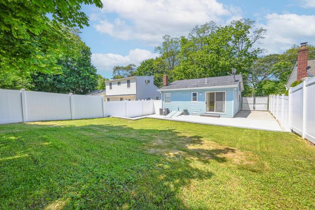 Rear view of house featuring a fenced backyard, a patio area, and a chimney | Image 16