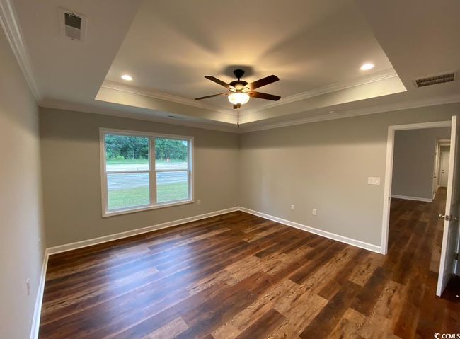 Spare room with a raised ceiling, ornamental molding, dark wood-style floors, ceiling fan, and baseboards | Image 6