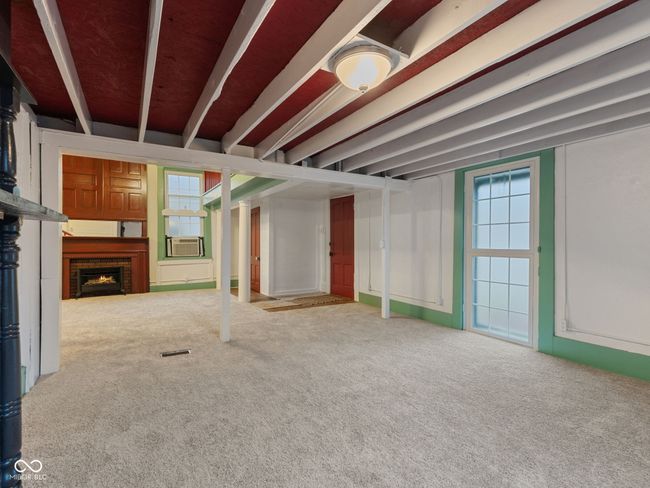 unfurnished living room with visible vents, cooling unit, carpet, and a brick fireplace | Image 7