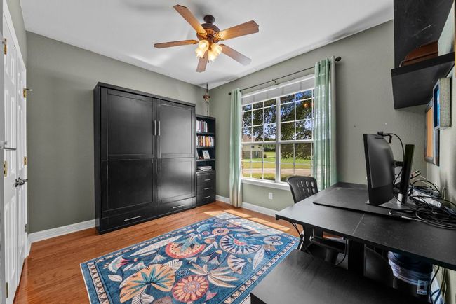 A practical Murphy bed in a secondary bedroom offers flexible space for guests or hobbies | Image 21