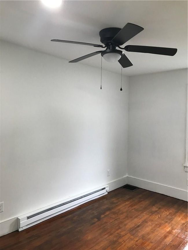 Spare room featuring a baseboard heating unit, dark hardwood / wood-style flooring, and ceiling fan | Image 19