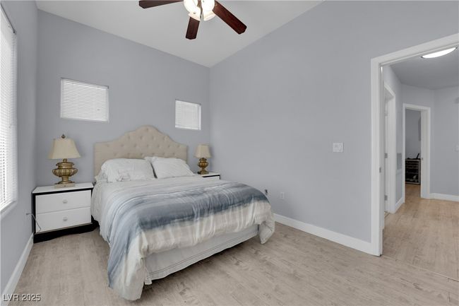 Bedroom with light wood-style floors, ceiling fan, and lofted ceiling | Image 26