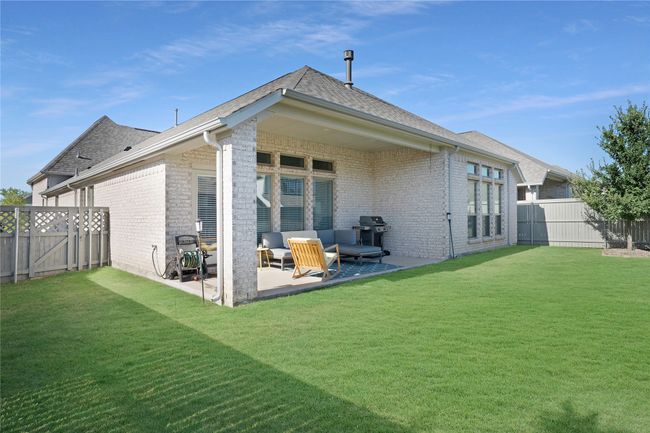 Back of house with a patio area, a fenced backyard, brick siding, and roof with shingles | Image 21