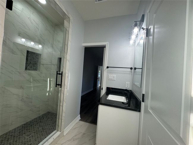 Full bathroom featuring marble finish flooring, a stall shower, and vanity | Image 18