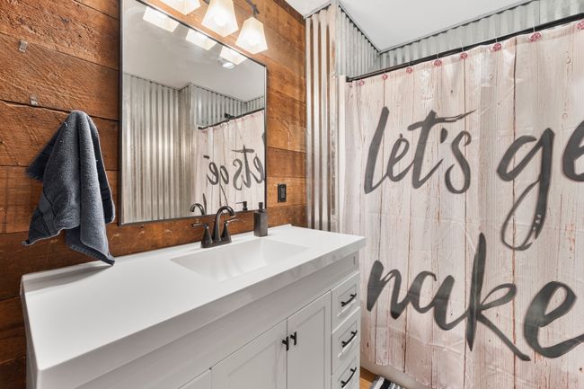 Full bath with wood walls, vanity, and a shower with curtain | Image 13