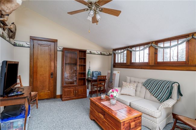 Living room with a ceiling fan, light carpet, and lofted ceiling | Image 23