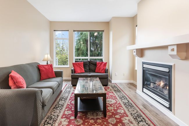 Living area featuring baseboards, light wood finished floors, and a glass covered fireplace | Image 8