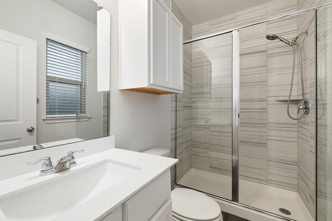 Bathroom featuring toilet, a stall shower, and vanity | Image 16