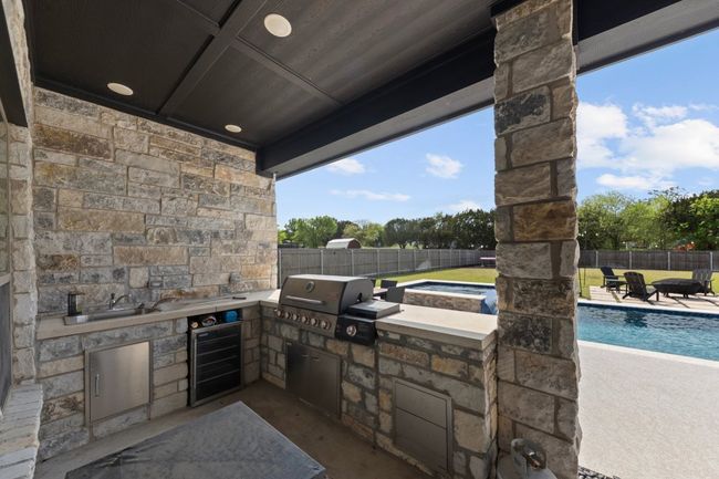View of patio / terrace with a fenced backyard, a grill, beverage cooler, and an outdoor kitchen | Image 38