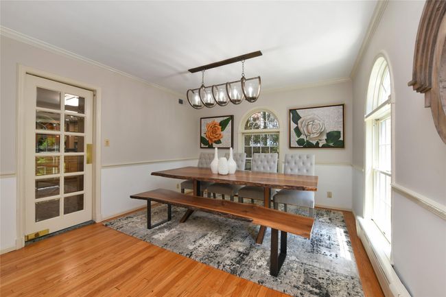 Dining space with a notable chandelier, crown molding, and wood finished floors | Image 4