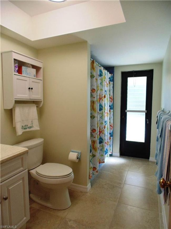 Full bathroom with a shower with curtain, vanity, tile patterned floors, toilet, and baseboards | Image 20