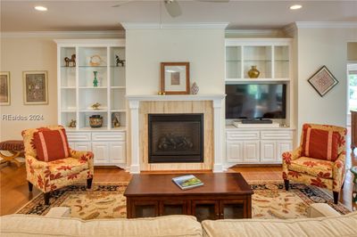 Living room featuring ceiling fan, crown molding, and light hardwood / wood-style flooring | Image 3