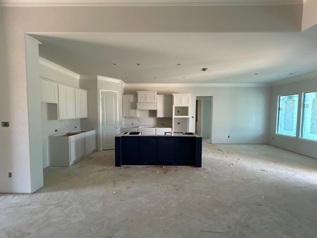 Kitchen with crown molding, white cabinets, and a center island | Image 4