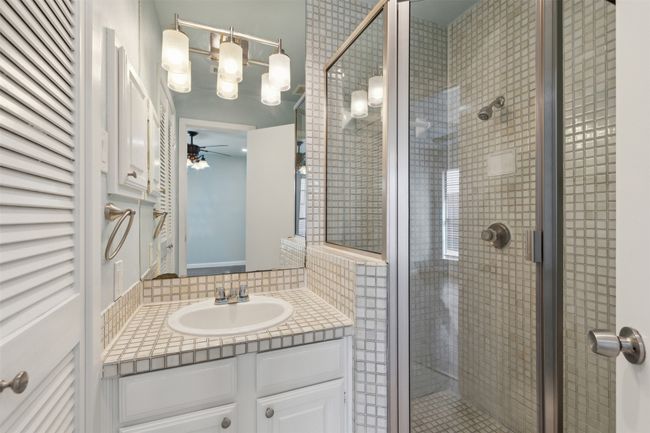Full bathroom featuring a ceiling fan, a stall shower, and vanity | Image 16