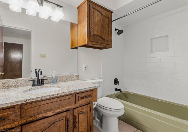 Full bathroom with vanity, toilet, tub / shower combination, and tile patterned floors | Image 20