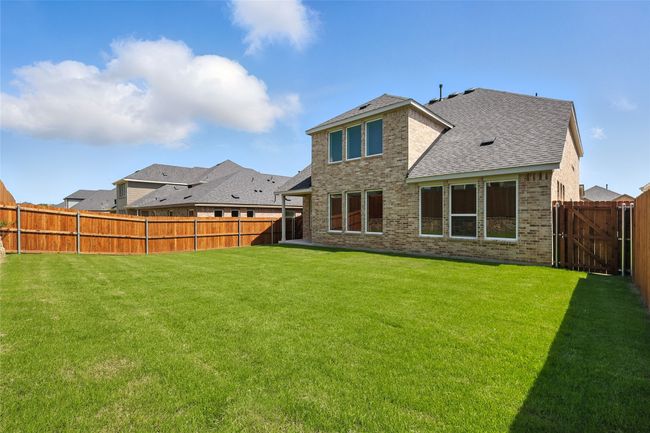 Back of house with brick siding, a fenced backyard, and roof with shingles | Image 33