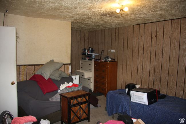 Carpeted bedroom with wood walls | Image 23