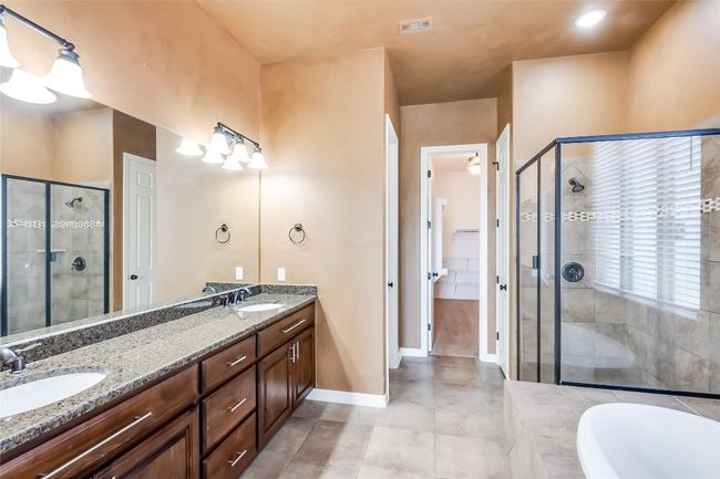 Full bath featuring double vanity, a sink, and a stall shower | Image 23