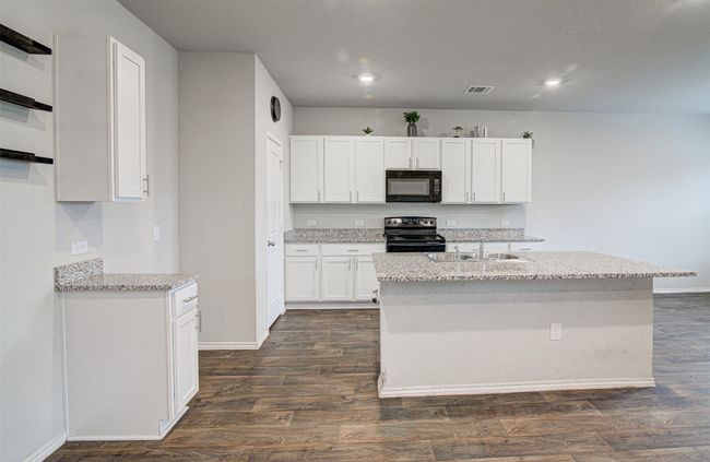 Kitchen with visible vents, a sink, black appliances, white cabinetry, and dark wood-type flooring | Image 15