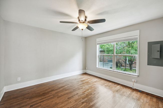 Empty room featuring wood finished floors, electric panel, and a ceiling fan | Image 11