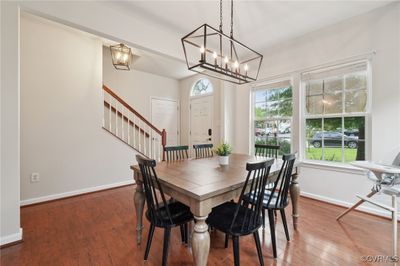 Dining room with a healthy amount of sunlight, an inviting chandelier, and hardwood / wood-style flooring | Image 3