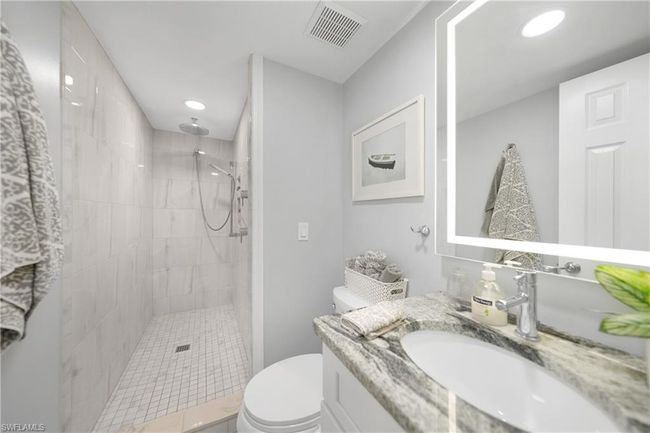 Bathroom featuring vanity, toilet, and tiled shower | Image 33