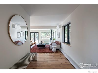 Foyer looking onto light filled living room -- notice the pano doors opening onto wraparound deck and the elegant STUV wood burning stove = cozy! | Image 2