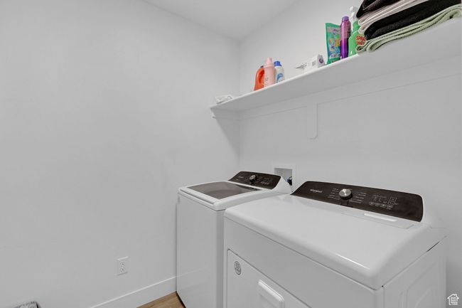 Washroom featuring independent washer and dryer, baseboards, and light wood finished floors | Image 16