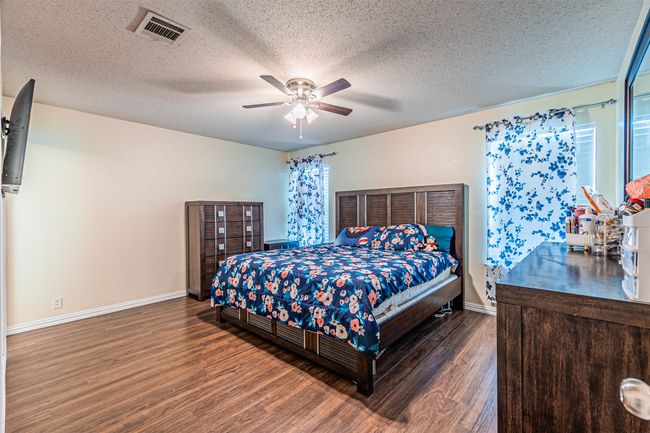 Master bedroom with wood finished floors | Image 12