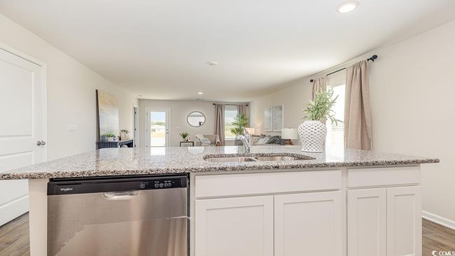 Kitchen featuring light stone countertops, sink, stainless steel dishwasher, and white cabinets | Image 6