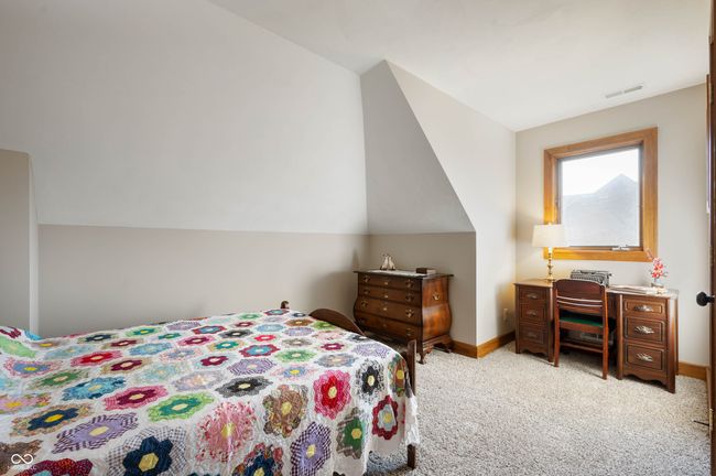 bedroom featuring visible vents, baseboards, light colored carpet, and vaulted ceiling | Image 26