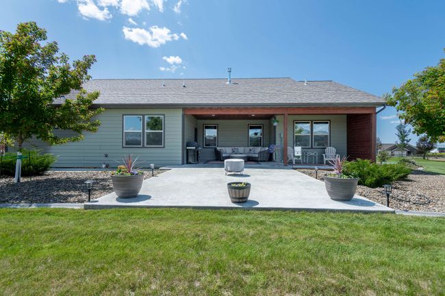 Back of property featuring an outdoor hangout area, a patio, a lawn, and roof with shingles | Image 4